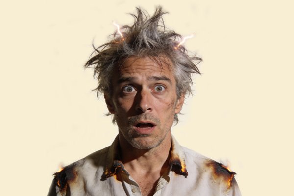 A wide-eyed man with his hair on end and his shirt singed, as if he's had an electric shock